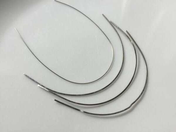Dây cung tác động lực lên răng giúp răng dịch chuyển về vị trí mong muốn